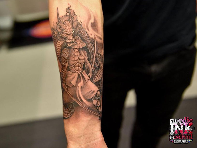 Samurai and dragon tattoo on arm at festival